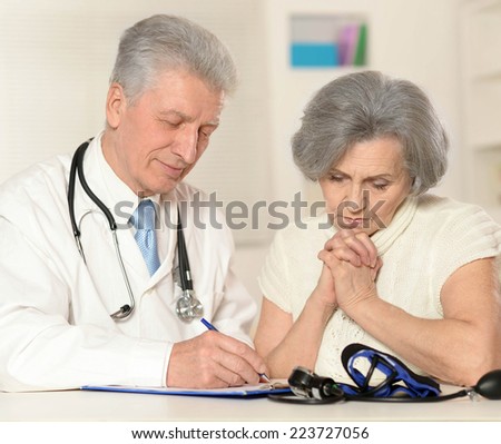 Elderly doctor with a patient on a white background