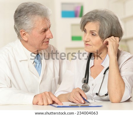 Portrait of  elderly doctor with a patient