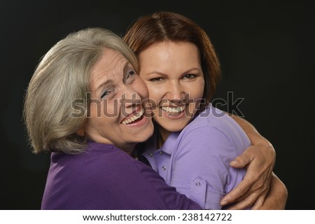 Portrait of a happy mother and daughter on black