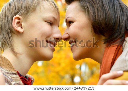 Sad mother with a son on a walk during the fall of the leaves in the park