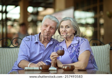 Senior couple drinking coffee outside at the resort during vacation