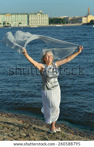 Pretty elderly woman went to the river to relax