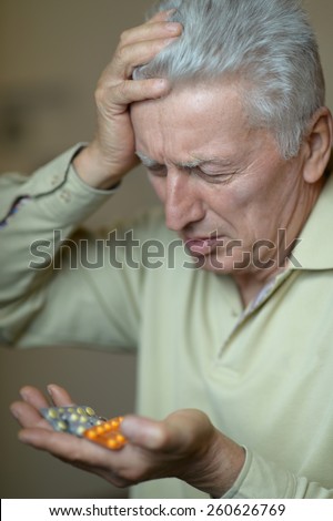 Close-up portrait of an older man taking a medicine