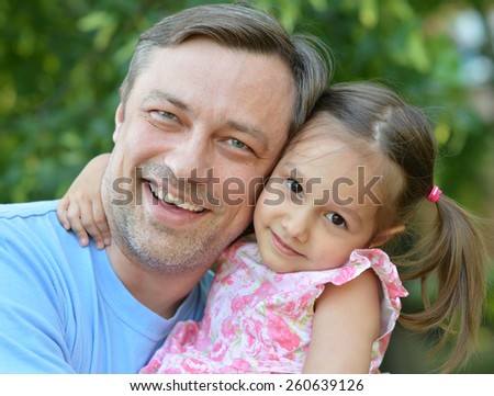 Father hugging his little daughter in nature