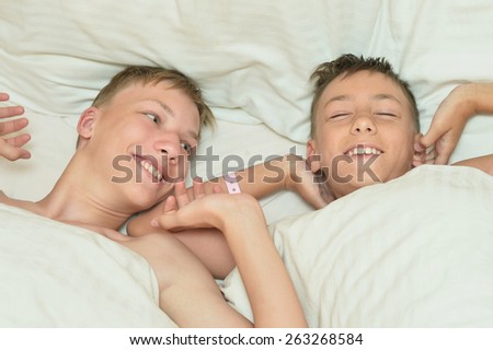 Portrait of two brothers waking up in bed