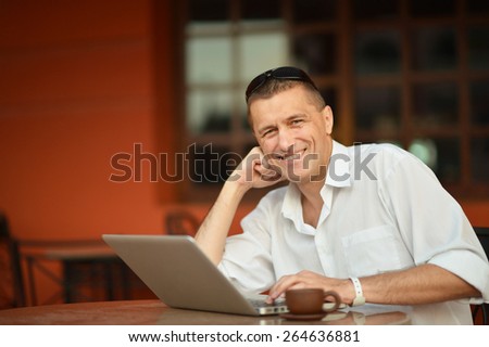 Portrait of a happy man with laptop on table