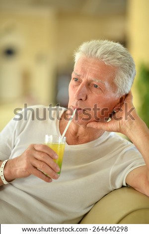 Senior man drinking juice at hotel resort