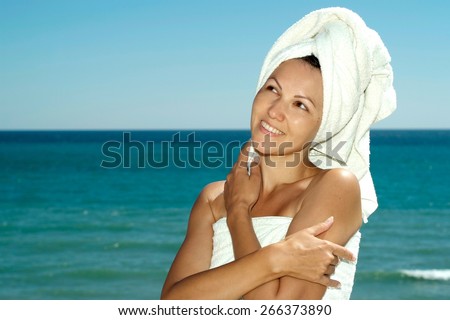 portrait of a young woman in towel on a background of the sea