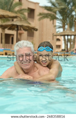 Portrait of a grandfather with grandson in swimming pool