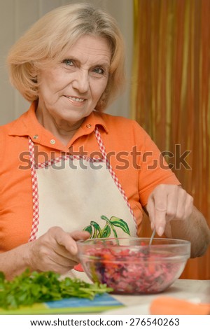 portrait of a beautiful elderly woman preparing dinner
