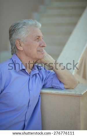 Serious senior man thinking in park on green background