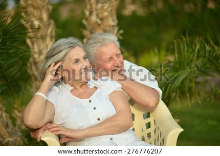 Senior couple have fun at tropic hotel garden