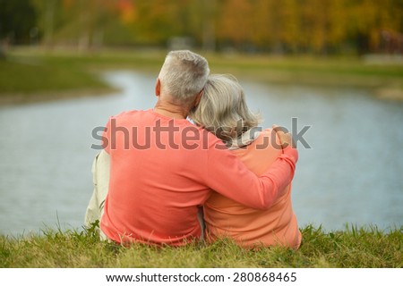 Back view of elderly couple together over natural background