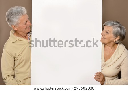 Old age couple holding blank banner and against white background
