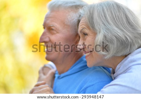 Happy senior couple relax in autumn park,back view