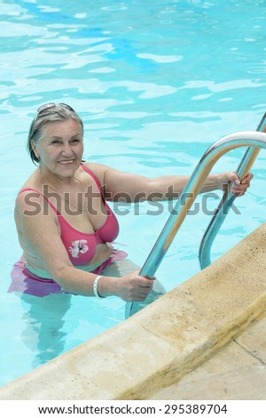 Portrait of a happy elderly woman  in swimming pool