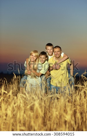 Portrait of a happy family in sunset wheat field