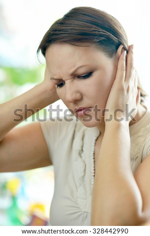 Sick woman with headache holding her head with hands