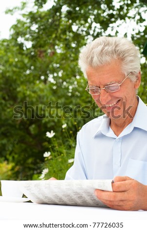 portrait of a man reading a newspaper at nature