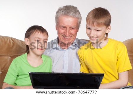 happy grandparent and grandsons with a laptop