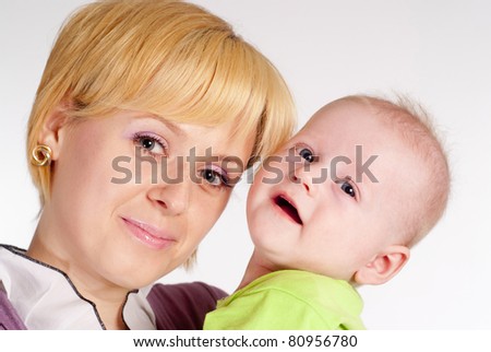happy mom holds her baby on white