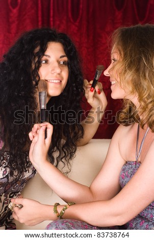 portrait of a cute two girls making up
