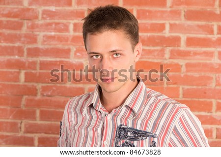 portrait of a cute guy at brick wall