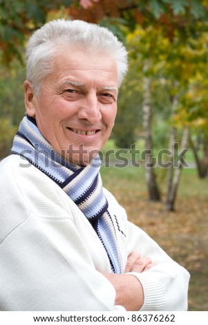 portrait of a nice old man posing at nature