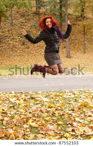 cute girl jumping at an autumn park
