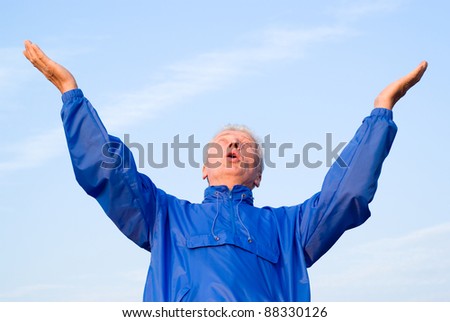 cute old man in blue posing at sky
