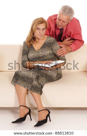 portrait of a cute old woman and man reading at couch