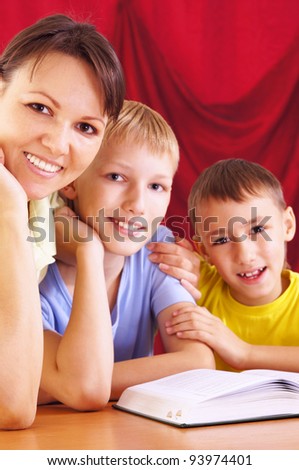cute mom reading with sons at table