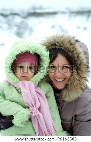 careful Mom and pretty daughter in the winter