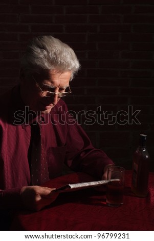 old man with newspaper in the dark