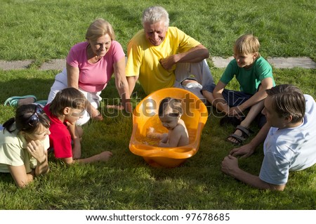 Caucasian nice family of six people around a baby in nature