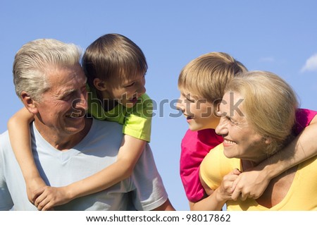 Happy Caucasian happy grandparents with grandchildren with fool on the street
