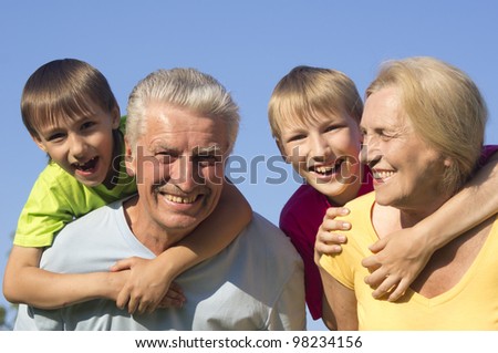 Happy Caucasian joy grandparents with grandchildren with fool on the street