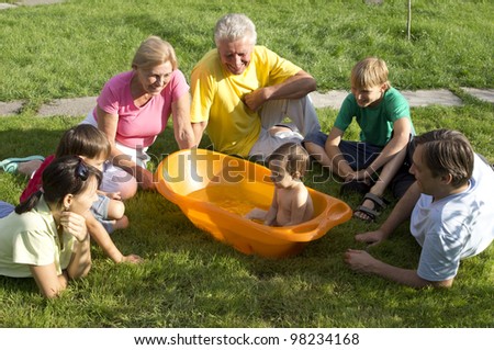 Caucasian nice happy family of six people around a baby in nature