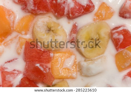 Fresh mixed fruit salad with banana, papaya,watermelon in milk