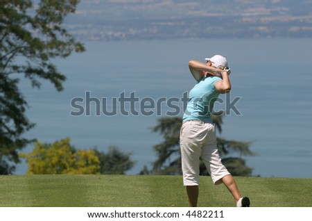 Lady golf swing over the Leman Lake