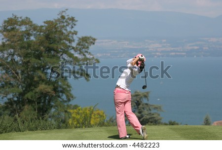 Lady golf swing over the Leman Lake