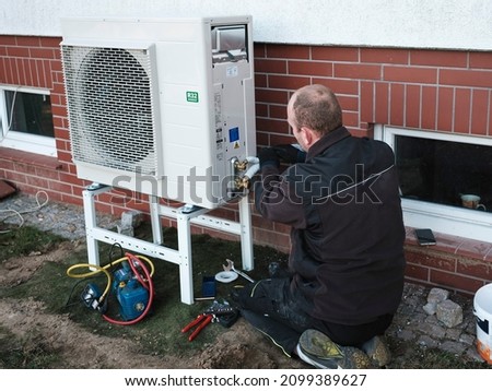 The installer installs the heat pump in a single-family house Imagine de stoc © 
