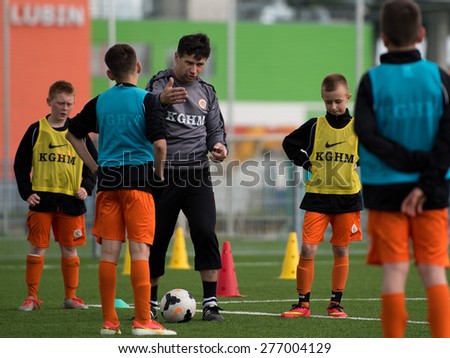 LUBIN, POLAND - MAY 7; 2015: Young players listen to their trainer at the training. Football academy KGHM Zaglebie is one of the biggest in Poland.