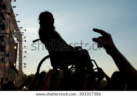 Kostrzyn Nad Odra, Poland. 30th JULY, 2015. Fans carry the disabled man during concert Polish band PRoletaryat at the 21 Festival Przystanek Woodstock. It is the biggest open music festival in Europe.