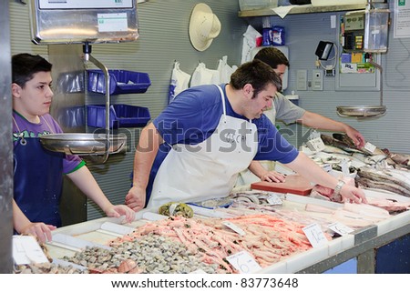 MALAGA, SPAIN - JUNE 10: Unidentified sellers pack the fishes at their shop in the popular central market on June 10, 2011 in Malaga, Spain. It was renovated in 2010 and it was reopened on March 2011.