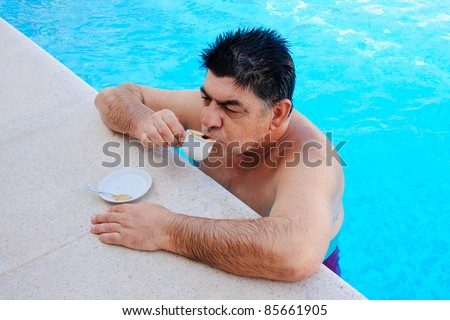 old man drinking coffee in a pool