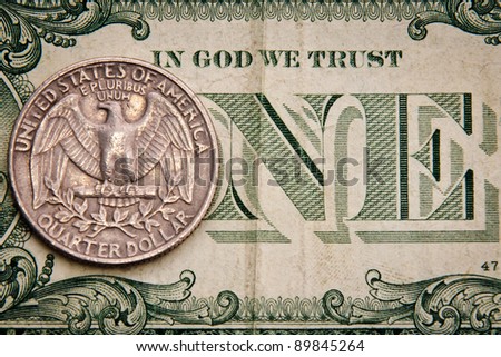 close-up of quarter dollar coin on the one dollar bill