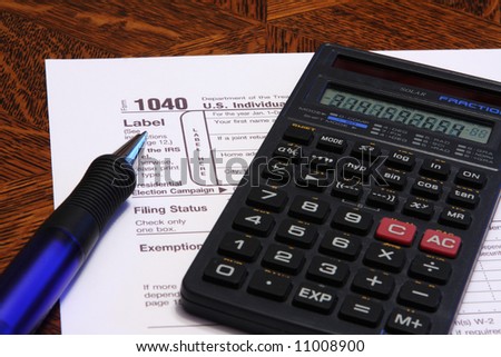 U.S. Income Tax Form 1040 with calculator and ink pen
