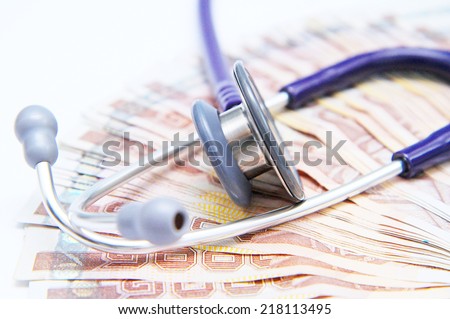Close-up of stethoscope on top of banknotes side view