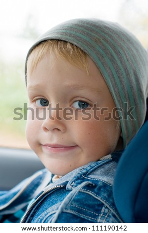 Five year old boy in a child car seat.